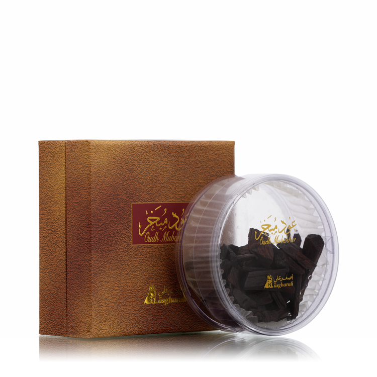 Side-by-side display of Oud Mubakhar box and transparent round container with oud chips.