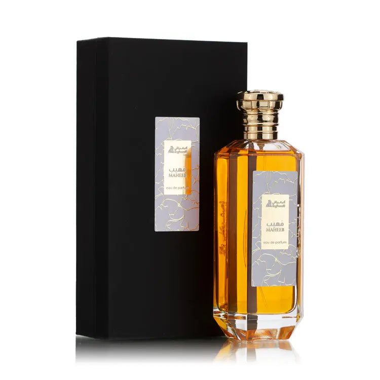 Maheeb eau de parfum bottle with golden cap placed next to its sleek black box featuring a matching light purple and gold floral label