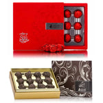 The image shows two boxes of chocolate. The top box is red with a silver clasp and adorned with small silver stars, while the bottom box is gold with the chocolate pieces visible inside.